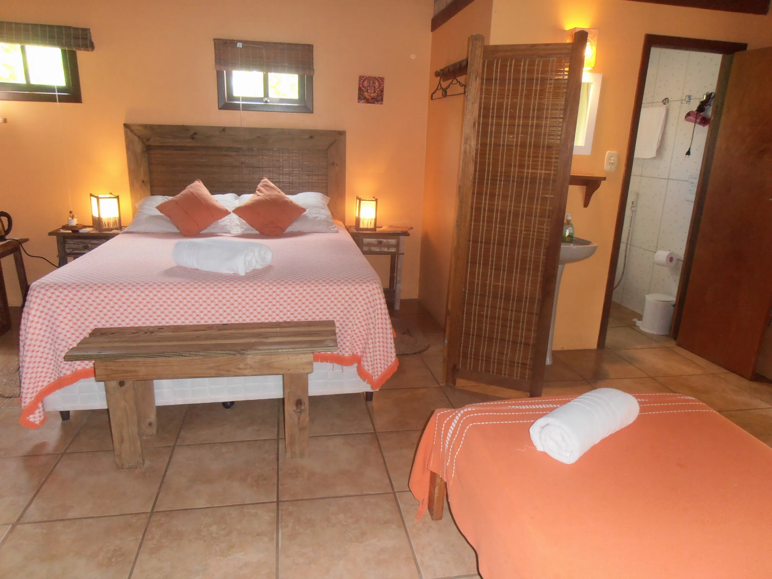 Bungalow 11 com cama de casal de cabeceira rústica e biombo de bambu