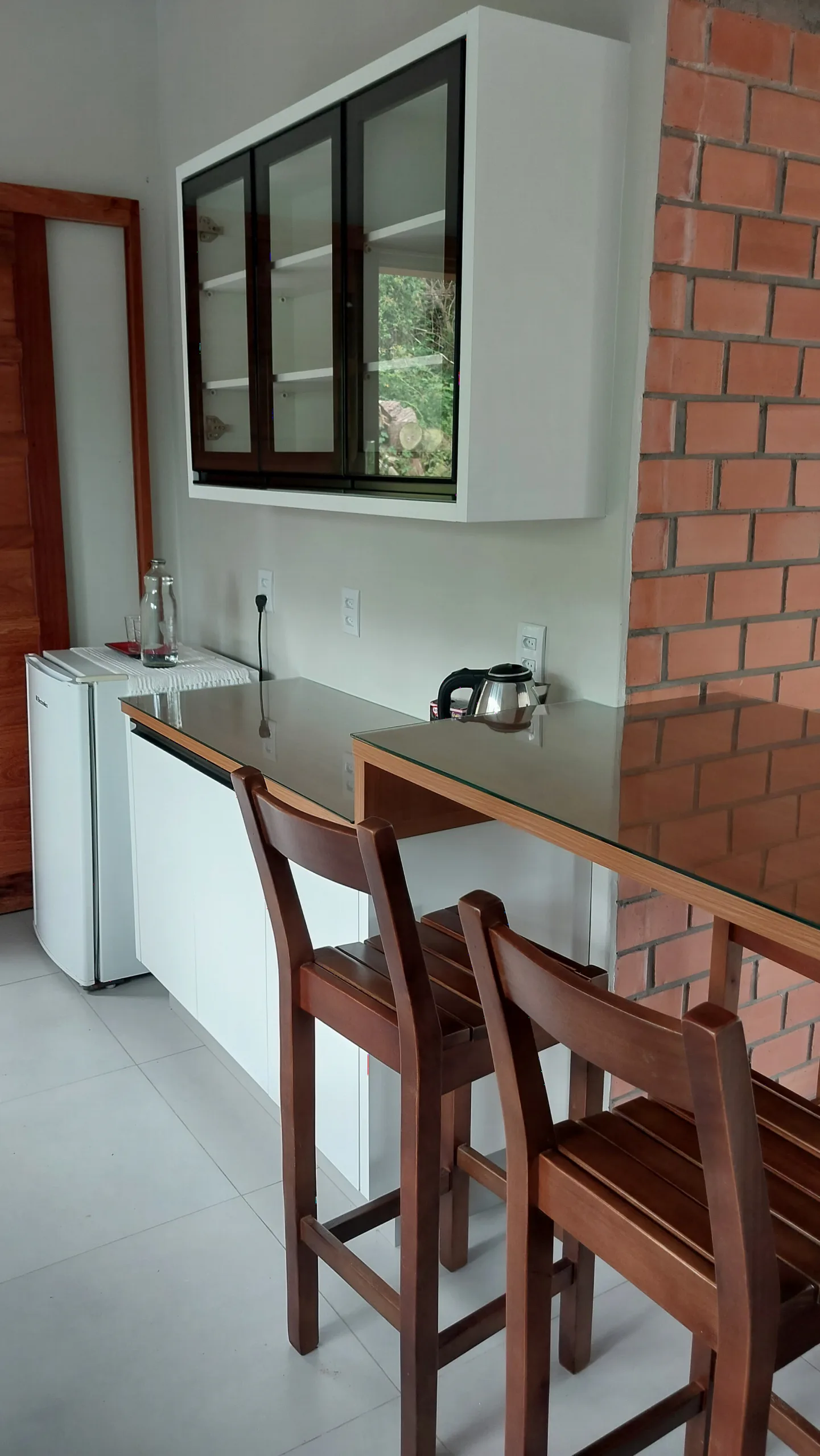 Bancada, armários e geladeira da cozinha do Bungalow 12