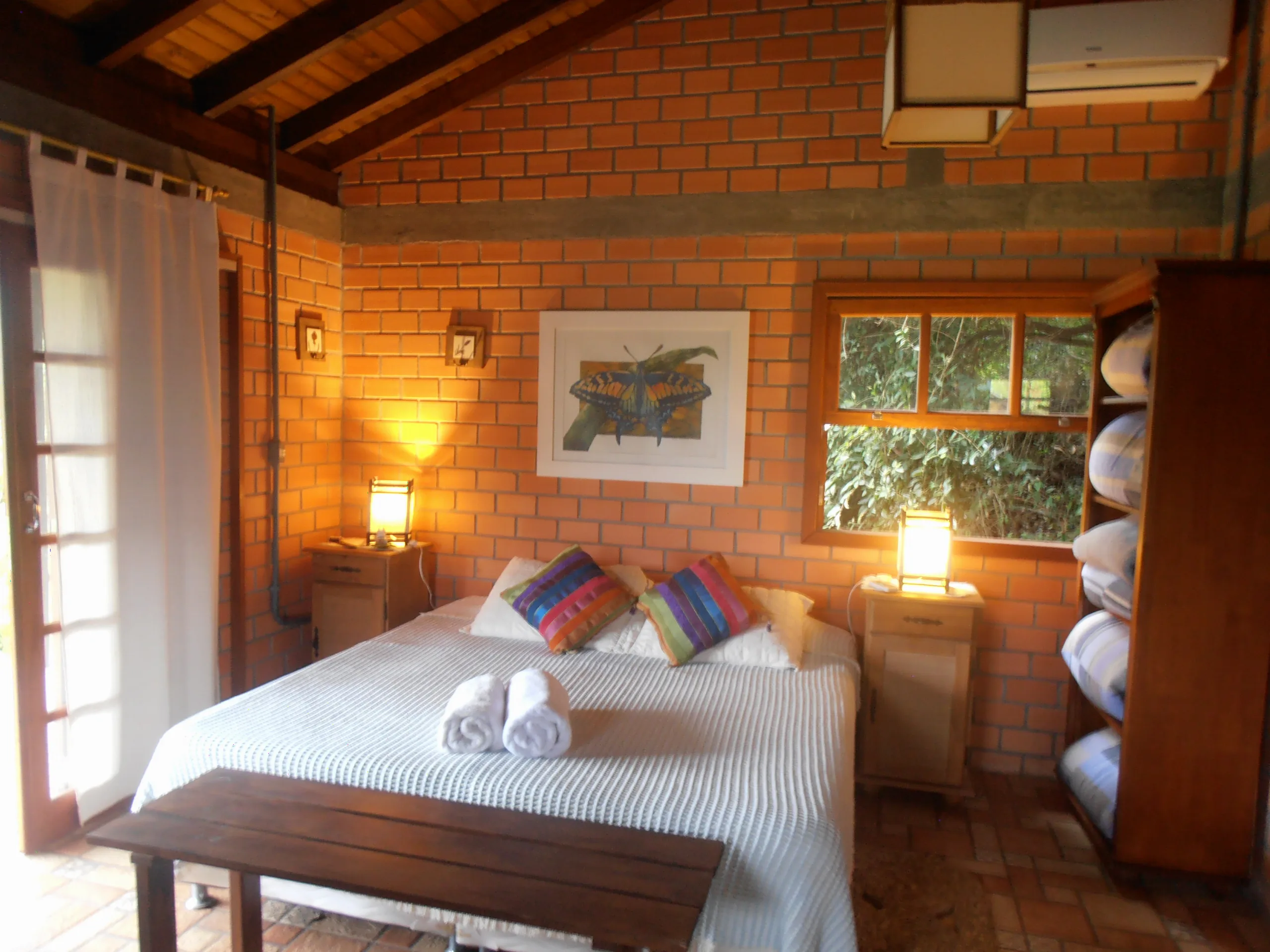 Bungalow 12 com cama de casal, parede de tijolinho e ar-condicionado