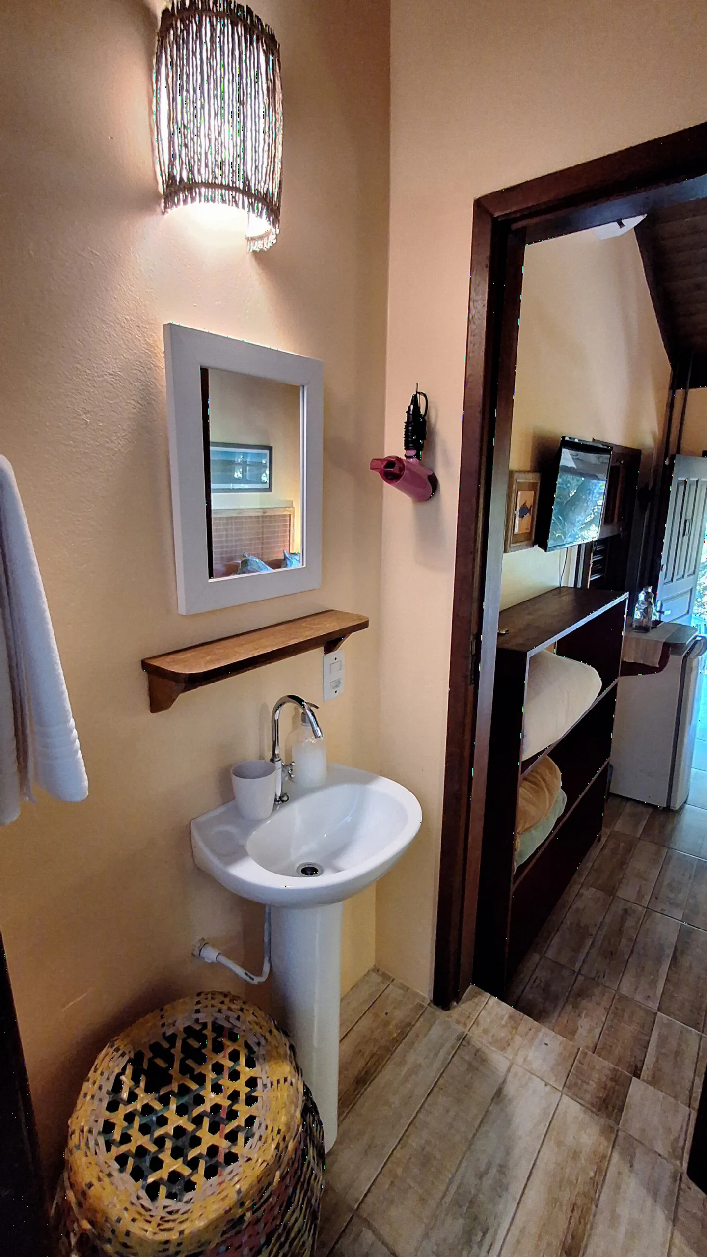 Lavabo da Suíte 10 com pia de coluna, espelho e luminária de fibra