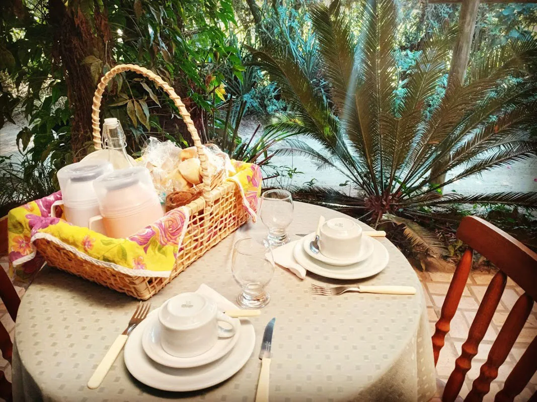 Cesta de café da manhã servida no jardim da pousada