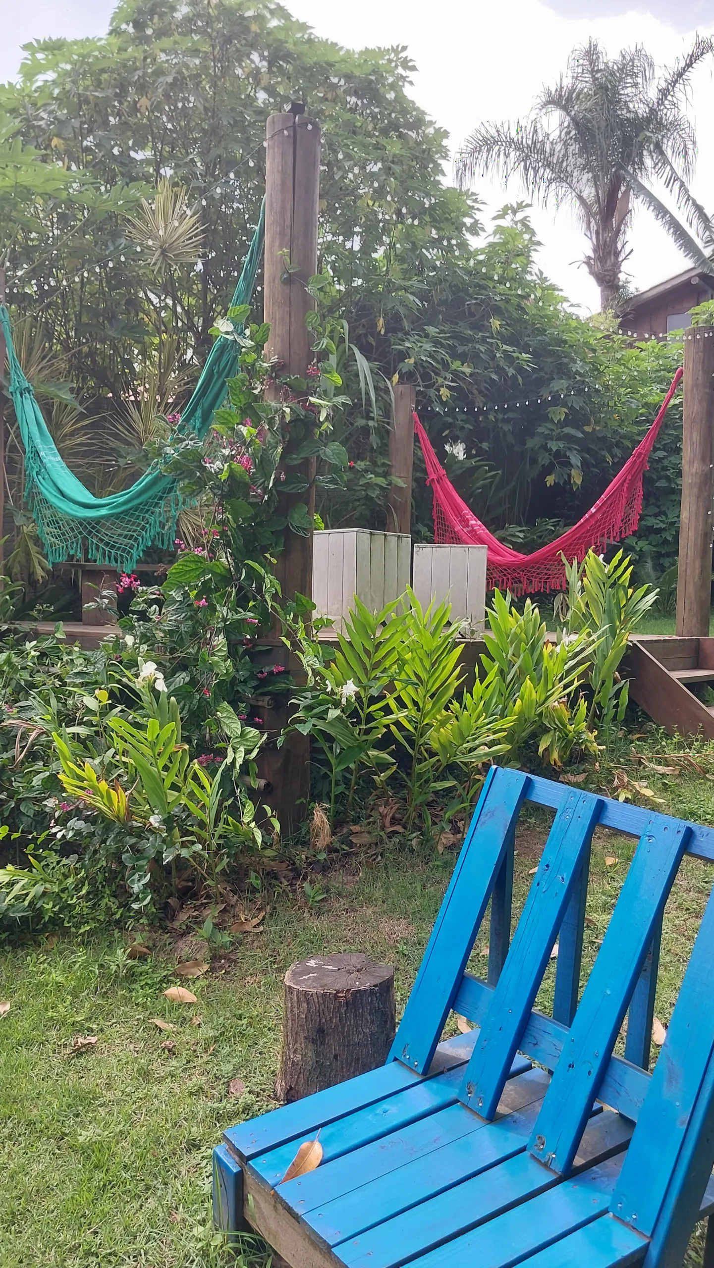 Redes coloridas do Espaço Zen e cadeiras azuis de madeira em meio ao jardim