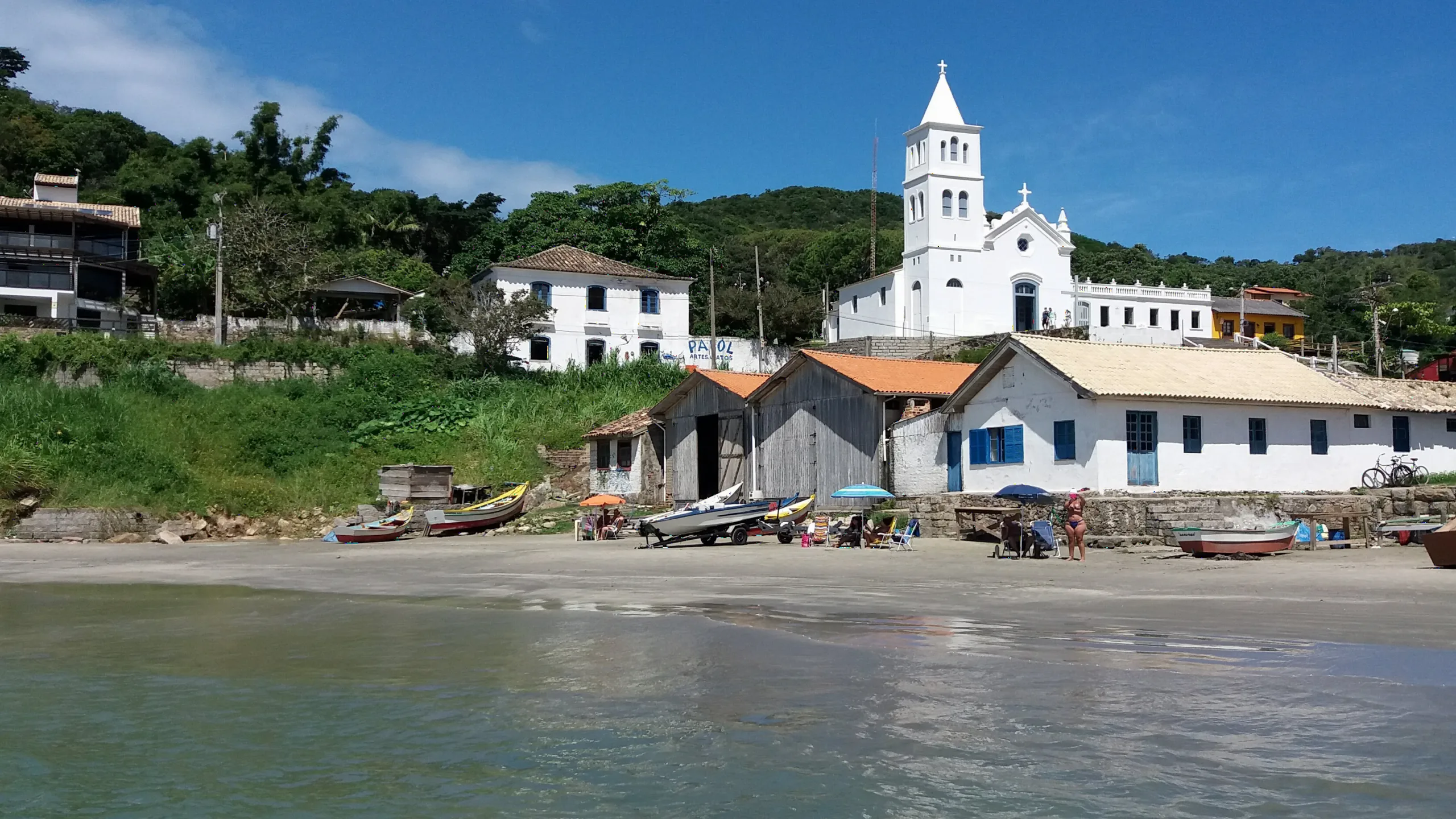 Igreja de Garopaba e casas de pescadores à beira-mar